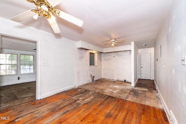 unfurnished living room with ceiling fan, hardwood / wood-style floors, and baseboards