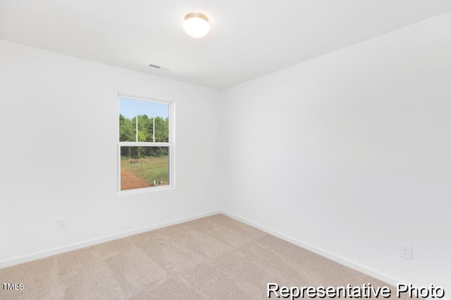 carpeted spare room featuring baseboards and visible vents