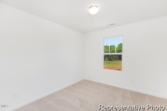 carpeted empty room featuring visible vents and baseboards
