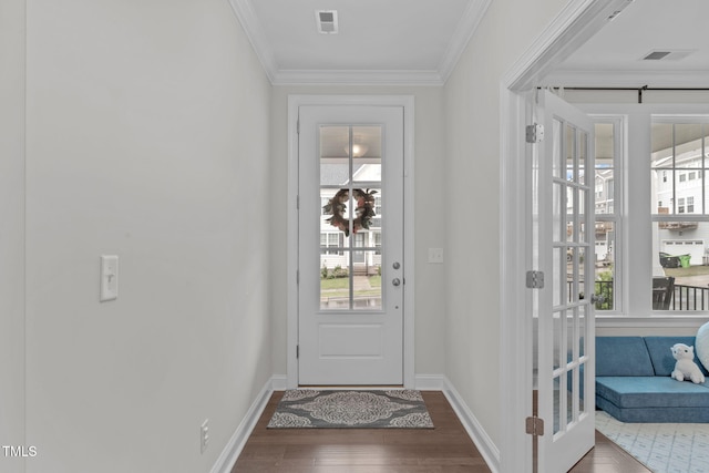 doorway to outside with wood finished floors, ornamental molding, and baseboards