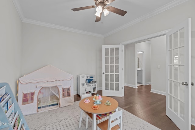 recreation room featuring french doors, crown molding, ceiling fan, wood finished floors, and baseboards