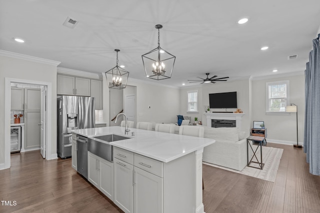 kitchen featuring a sink, appliances with stainless steel finishes, ceiling fan, beverage cooler, and light countertops