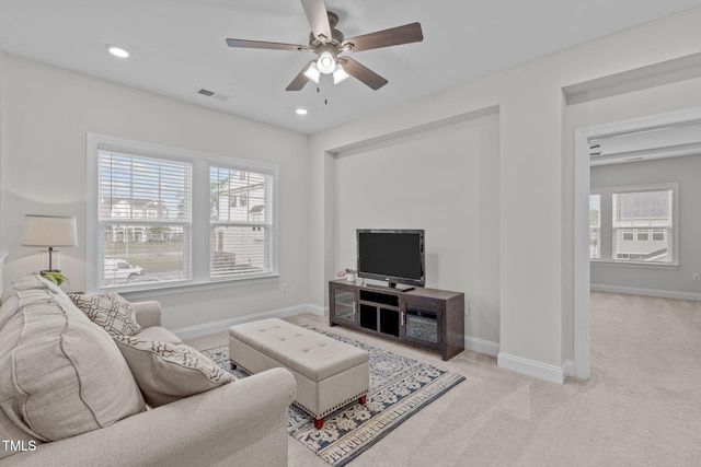 living area featuring light colored carpet, a ceiling fan, baseboards, and recessed lighting