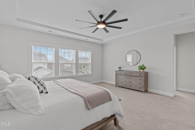 bedroom featuring a raised ceiling, carpet flooring, baseboards, and a ceiling fan