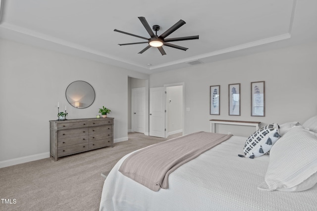 carpeted bedroom featuring a tray ceiling, baseboards, and ceiling fan