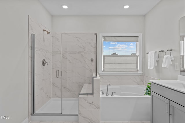 bathroom with a stall shower, a garden tub, vanity, and recessed lighting