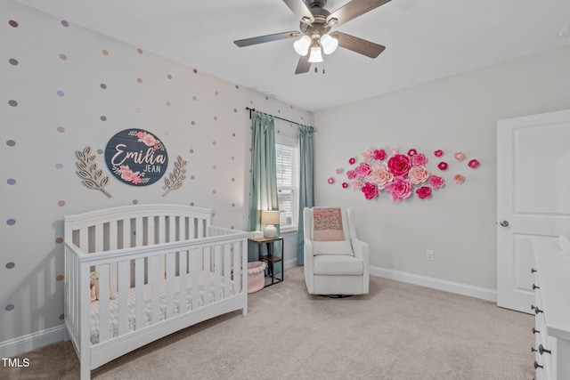 bedroom featuring carpet flooring, a crib, and baseboards