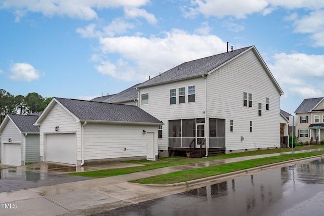 view of side of property featuring a sunroom, a garage, roof with shingles, driveway, and crawl space