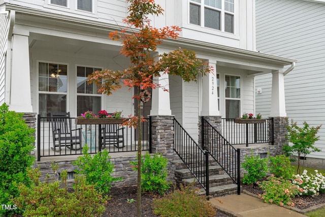 view of exterior entry with a porch and stone siding