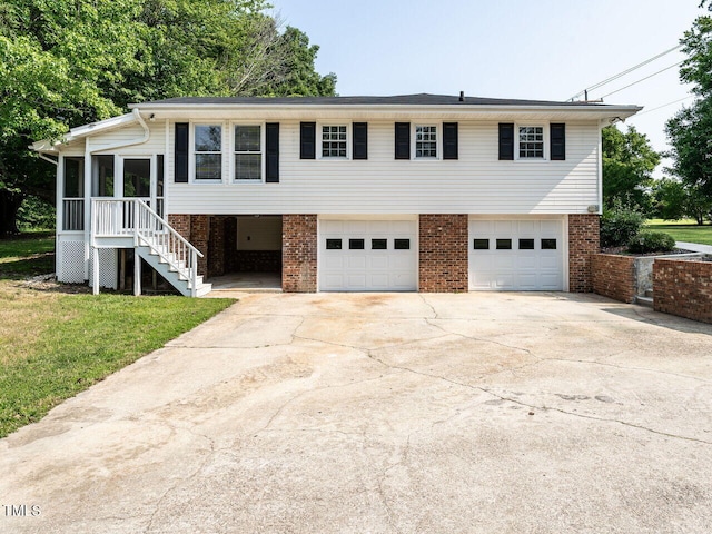 1612 Bethlehem Rd, Knightdale, NC 27545 - view of front of house with an attached garage, concrete driveway, brick siding, stairs, and a front yard