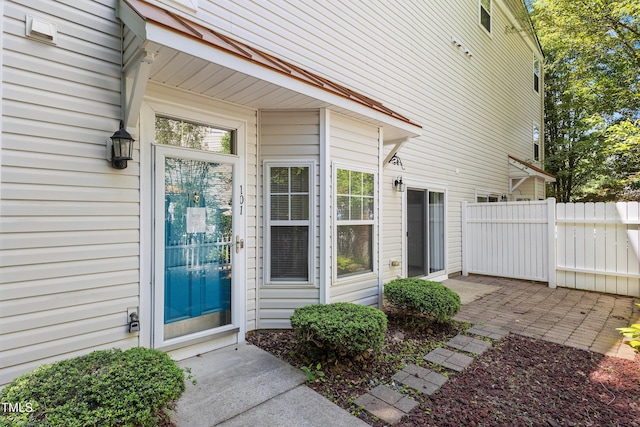 property entrance featuring fence and a patio area