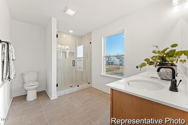 full bath with a stall shower, baseboards, toilet, tile patterned floors, and double vanity