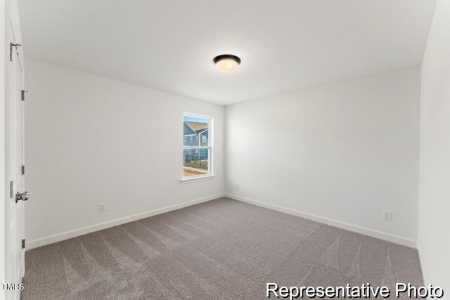 spare room featuring baseboards and carpet