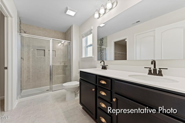 260 Curling Creek Dr Unit 235P, Clayton, NC 27527 - full bath featuring double vanity, a shower stall, toilet, tile patterned floors, and a walk in closet