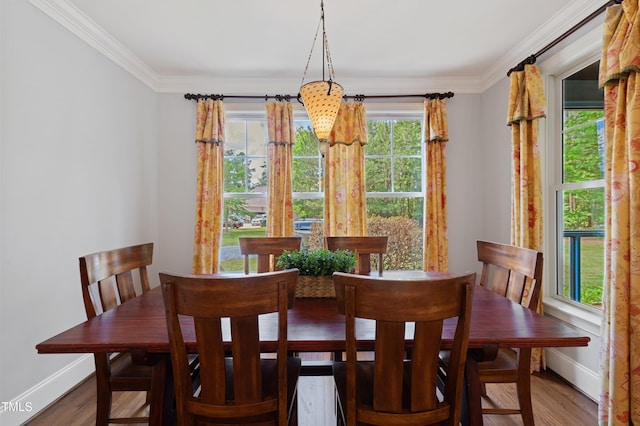 dining area with baseboards, ornamental molding, and wood finished floors
