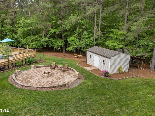 3653 Range Rd, Stem, NC 27581 - view of grassy yard with an outdoor fire pit, an outdoor structure, a wooden deck, a patio area, and a forest view