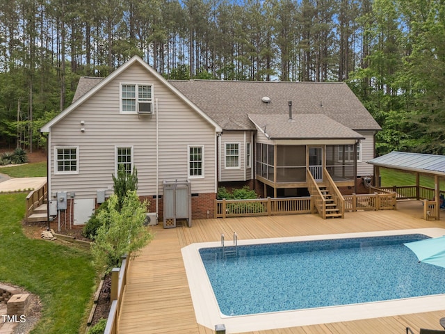 3653 Range Rd, Stem, NC 27581 - back of house with a deck, a sunroom, an outdoor pool, a shingled roof, and view of wooded area