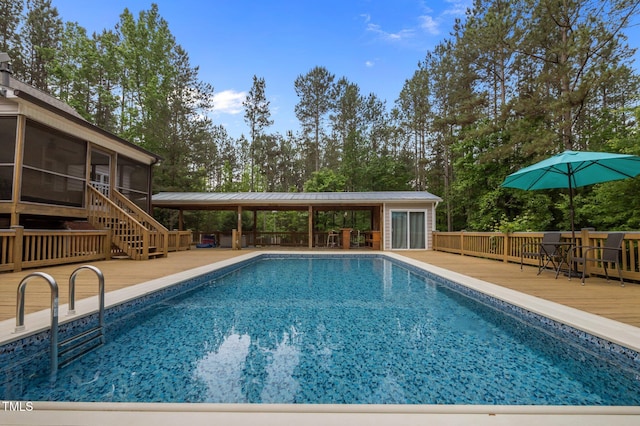 3653 Range Rd, Stem, NC 27581 - view of swimming pool featuring a wooden deck, a sunroom, and view of wooded area