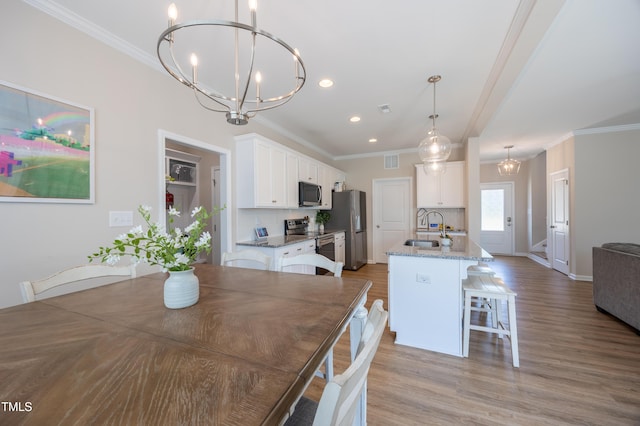 4524 Sweet Williams Ln NW, Wilson, NC 27896 - dining room featuring a notable chandelier, recessed lighting, ornamental molding, light wood finished floors, and visible vents