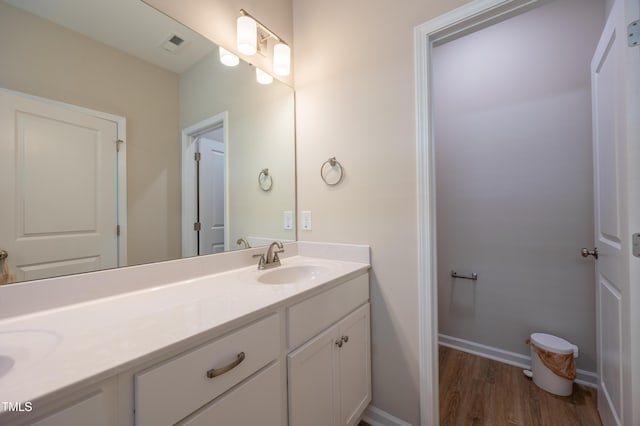 4524 Sweet Williams Ln NW, Wilson, NC 27896 - bathroom with double vanity, wood finished floors, a sink, visible vents, and baseboards