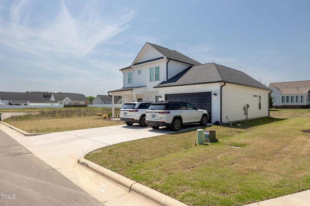 4524 Sweet Williams Ln NW, Wilson, NC 27896 - view of side of home with board and batten siding, concrete driveway, an attached garage, and a lawn
