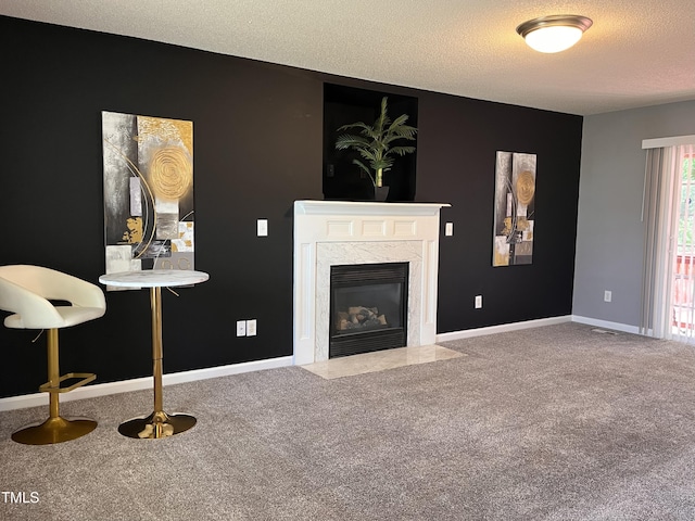 unfurnished living room featuring a textured ceiling, a fireplace, baseboards, and carpet floors