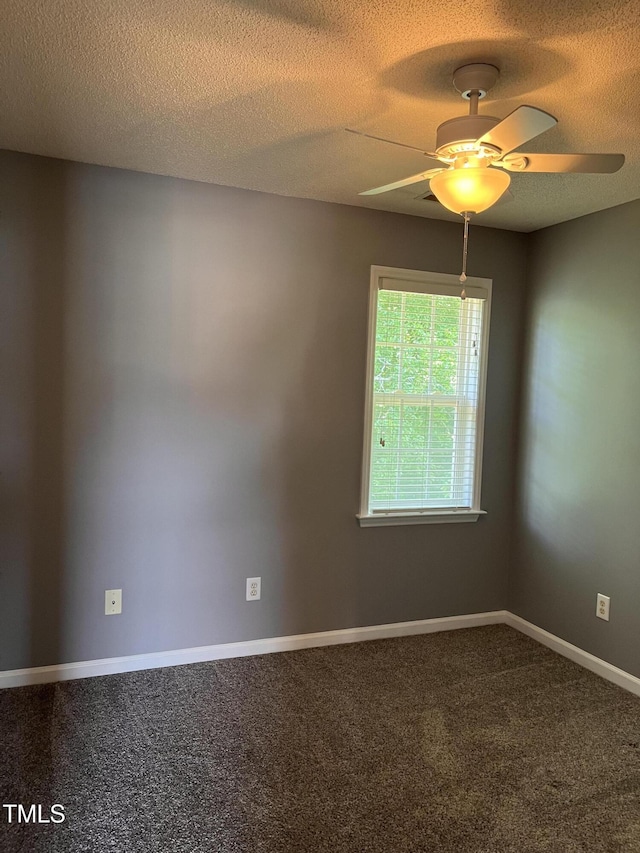 carpeted spare room featuring a textured ceiling, baseboards, and a ceiling fan