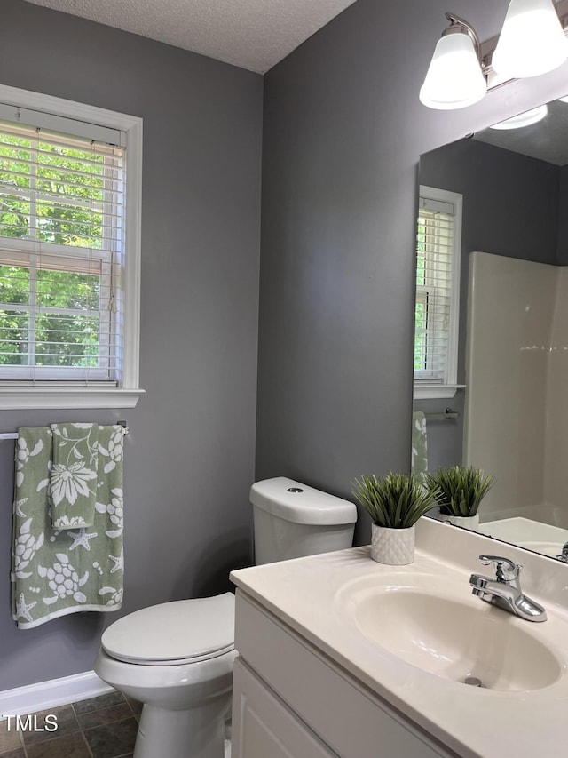 half bath featuring vanity, toilet, and a textured ceiling