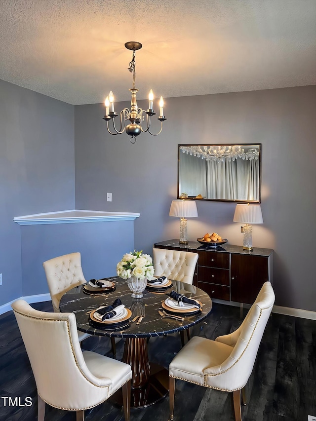 dining room with a textured ceiling, a chandelier, wood finished floors, and baseboards