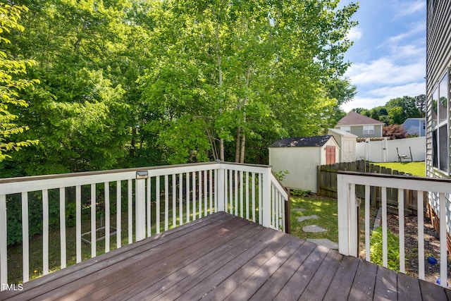 wooden deck with a storage shed and an outdoor structure