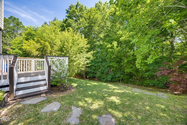 view of grassy yard with a deck