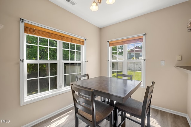 dining room with baseboards, wood finished floors, and a chandelier