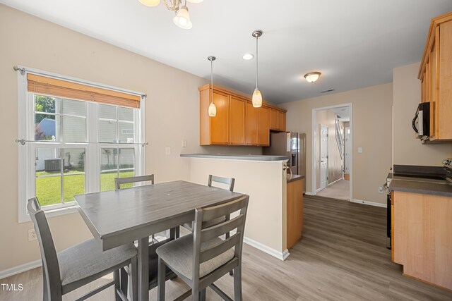 dining space with baseboards, light wood-style floors, and recessed lighting