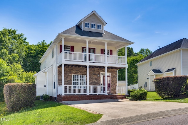 view of front of home with a porch, a balcony, a front yard, and stone siding