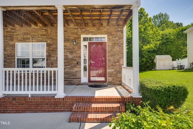 property entrance with stone siding, a porch, and central AC unit