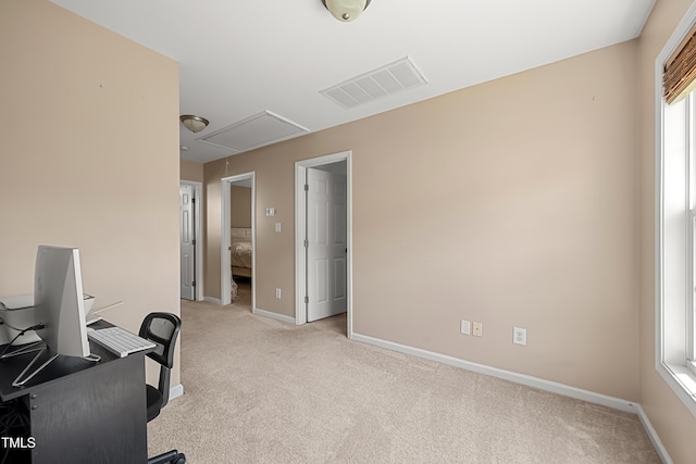 office space with attic access, light carpet, and baseboards