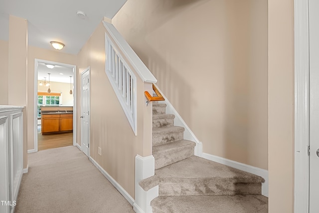 stairs with carpet floors and baseboards