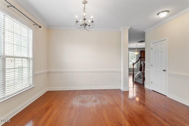 unfurnished room with a chandelier, stairway, wood finished floors, baseboards, and crown molding