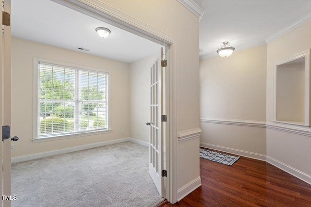 hall featuring baseboards, crown molding, and wood finished floors