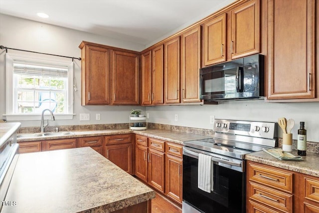 kitchen with stainless steel range with electric stovetop, black microwave, a sink, brown cabinets, and recessed lighting