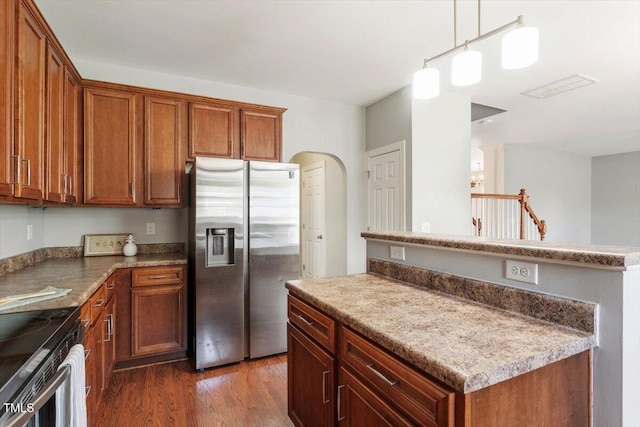 kitchen featuring stainless steel refrigerator with ice dispenser, electric stove, brown cabinets, and a kitchen island
