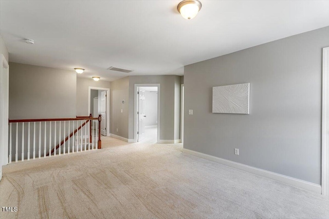 carpeted spare room with baseboards and a smoke detector