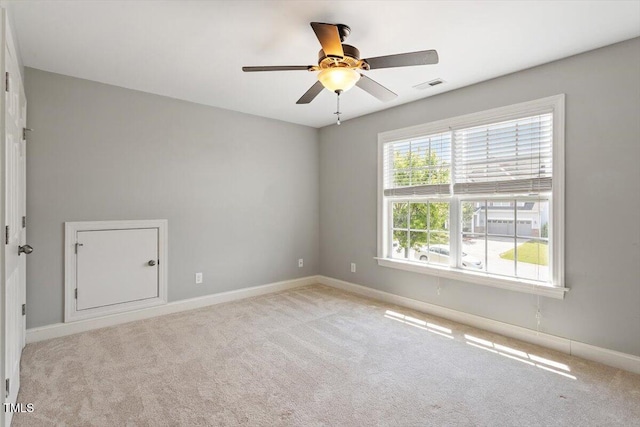 spare room with baseboards, carpet floors, and a ceiling fan