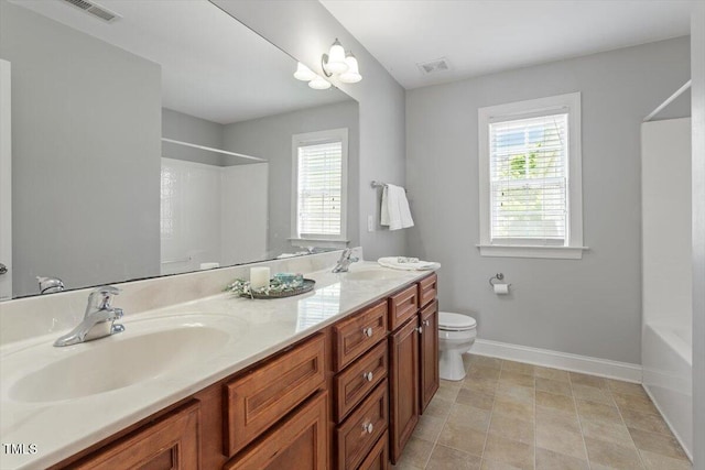bathroom with plenty of natural light, baseboards, toilet, and double vanity