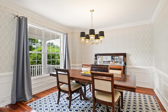 dining space featuring wood finished floors, a chandelier, wallpapered walls, wainscoting, and ornamental molding