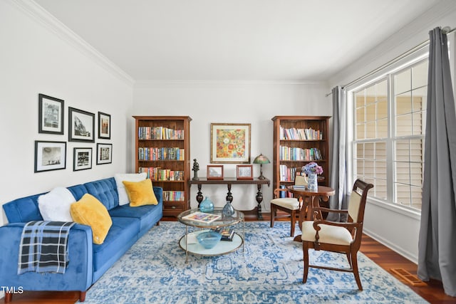 living area with wood finished floors, crown molding, and baseboards