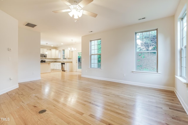 unfurnished living room with baseboards, light wood-style floors, and visible vents