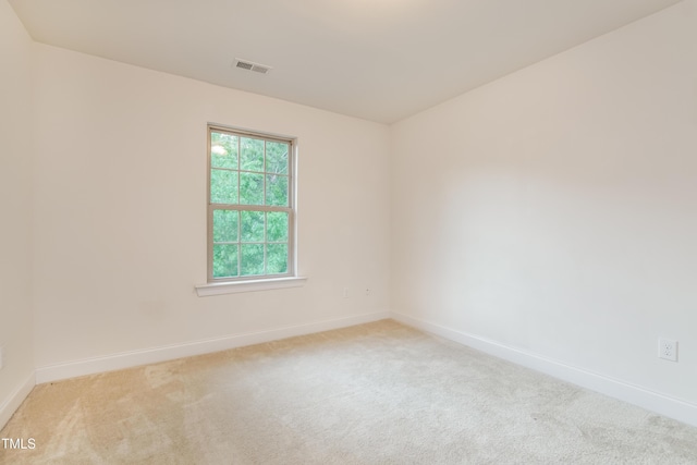 carpeted empty room featuring baseboards and visible vents