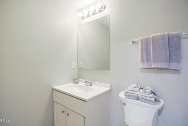 half bathroom featuring vanity and toilet