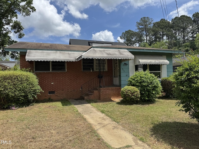 bungalow-style house with brick siding, a front lawn, and crawl space